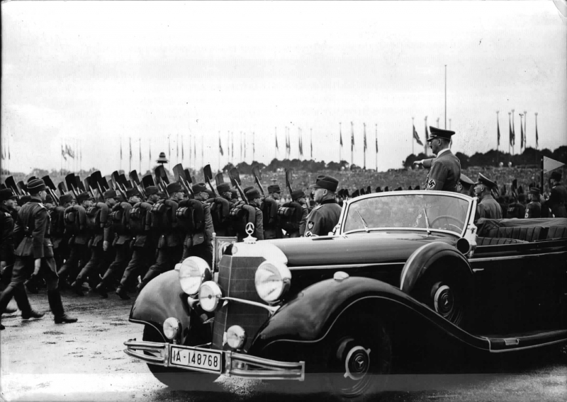 Formations of the Reich Labour Service parading past Adolf Hitler at the rally ground